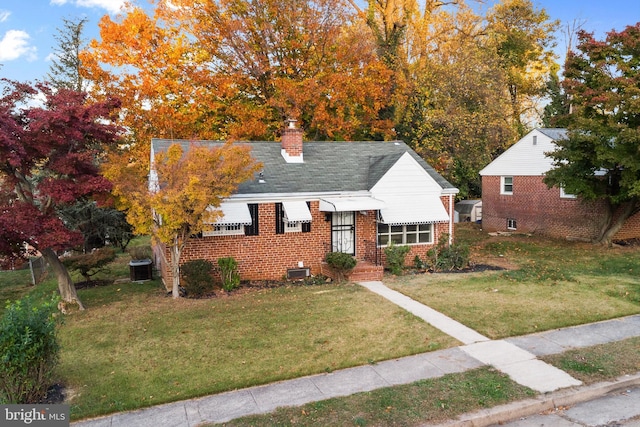 view of front of property with central AC unit and a front yard