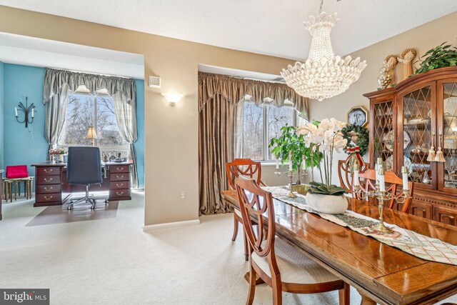 carpeted dining area featuring a chandelier