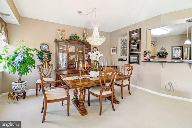 dining area with light carpet and an inviting chandelier