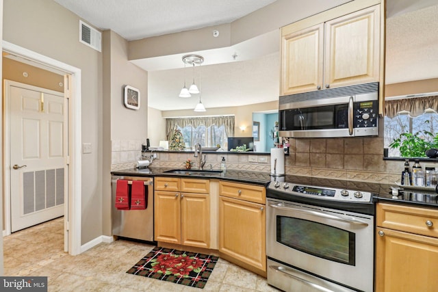 kitchen with sink, stainless steel appliances, tasteful backsplash, pendant lighting, and a textured ceiling