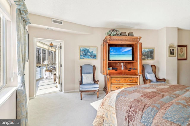 bedroom featuring light colored carpet and multiple windows