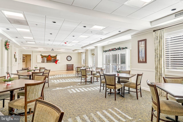 dining space featuring a drop ceiling and carpet floors