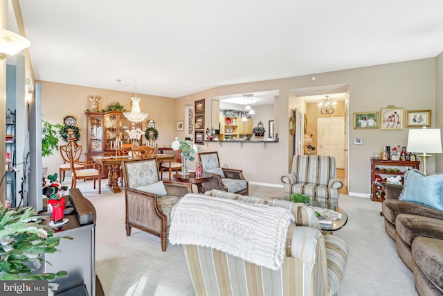 carpeted living room featuring an inviting chandelier