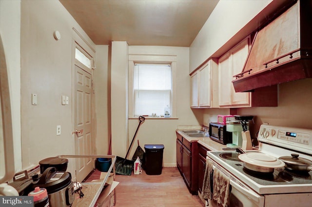 kitchen featuring white electric range, light wood-type flooring, extractor fan, and sink