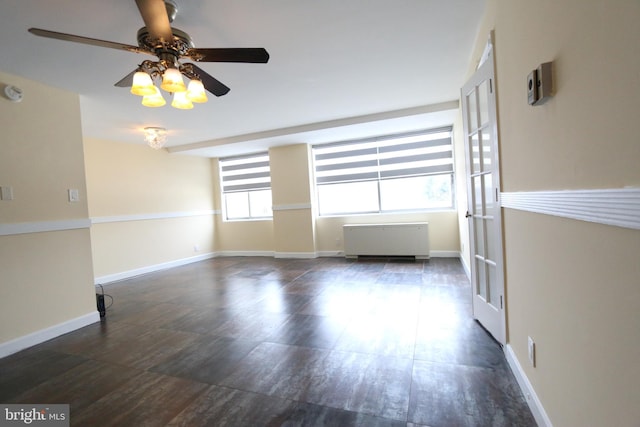 spare room with radiator heating unit and ceiling fan