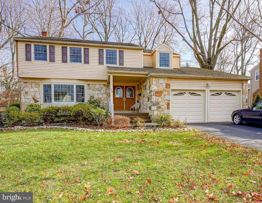 view of property featuring a front lawn and a garage