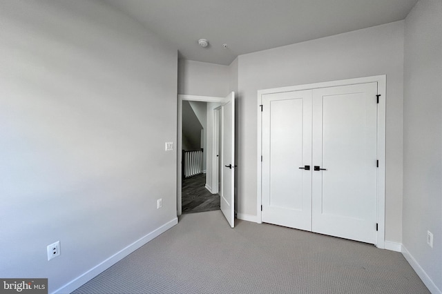 unfurnished bedroom featuring light carpet and a closet