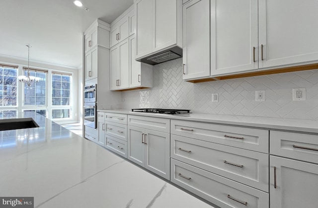 kitchen with white cabinetry, light stone countertops, stainless steel appliances, backsplash, and pendant lighting