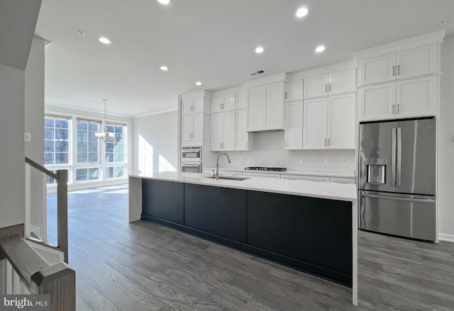 kitchen with gas cooktop, stainless steel fridge, white cabinetry, and sink