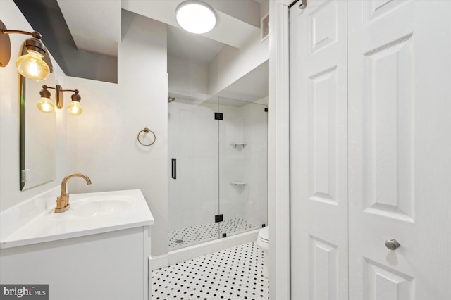 bathroom with vanity, toilet, and a shower with door