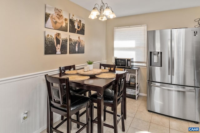 dining space featuring light tile patterned floors and a notable chandelier