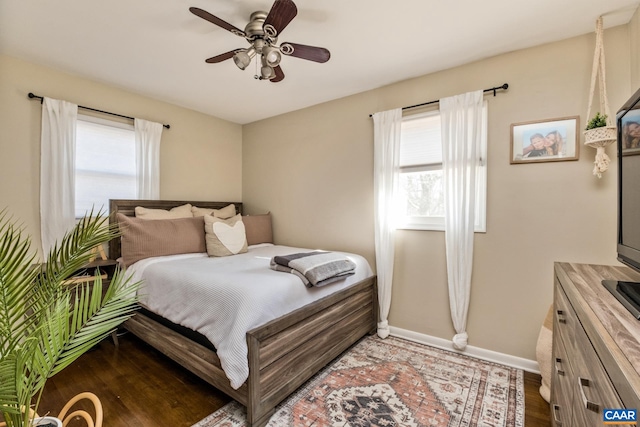 bedroom with multiple windows, wood-type flooring, and ceiling fan