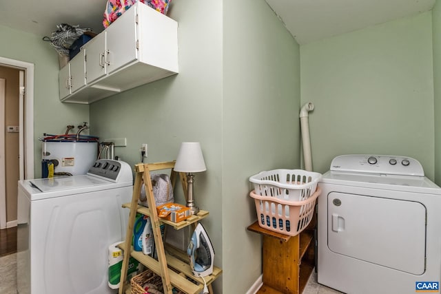 washroom featuring cabinets, electric water heater, and washing machine and clothes dryer