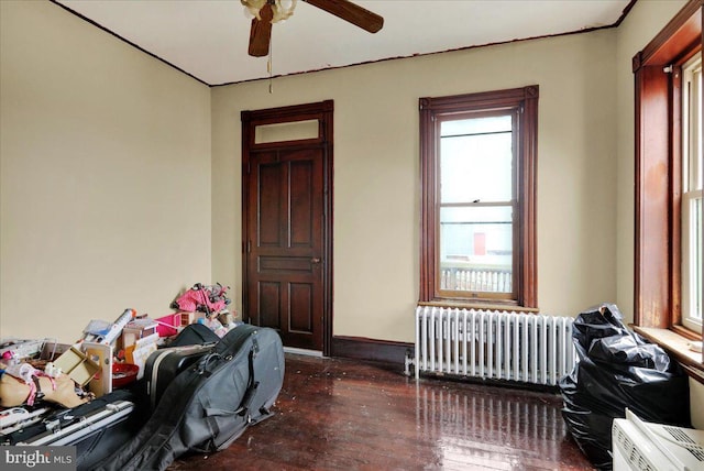 misc room with ceiling fan, radiator heating unit, and dark wood-type flooring