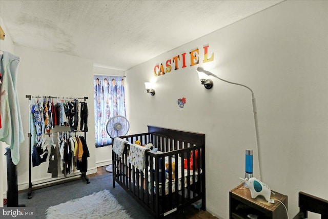 bedroom featuring a textured ceiling and a nursery area