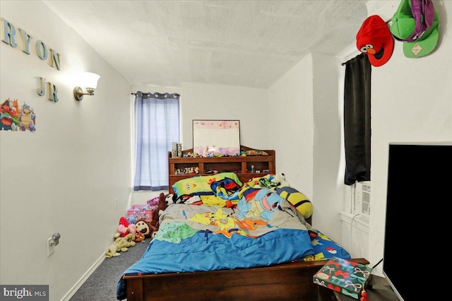 bedroom featuring carpet and a textured ceiling