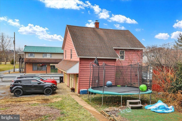 back of property featuring a trampoline