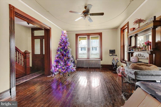 interior space with ceiling fan, crown molding, radiator heating unit, and dark wood-type flooring