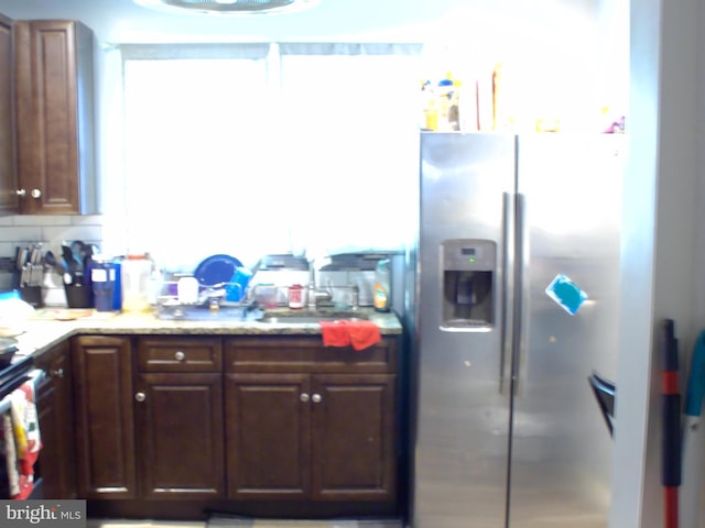 kitchen with decorative backsplash, stainless steel fridge, and sink