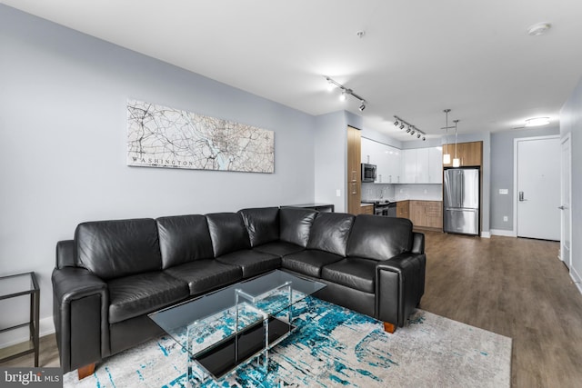 living area with track lighting, baseboards, and wood finished floors