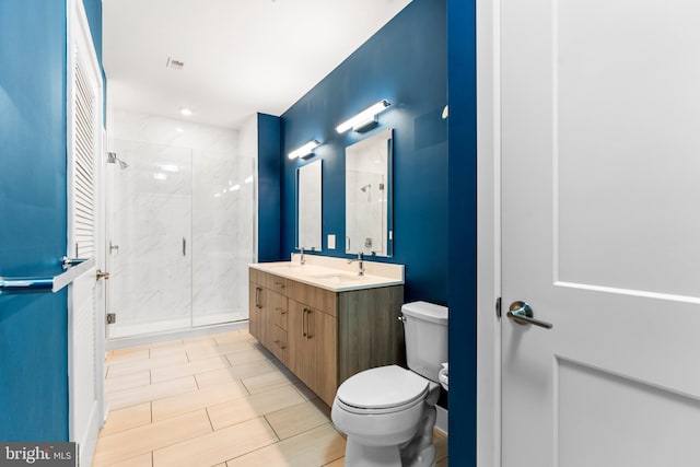 bathroom featuring a sink, a shower stall, toilet, and double vanity