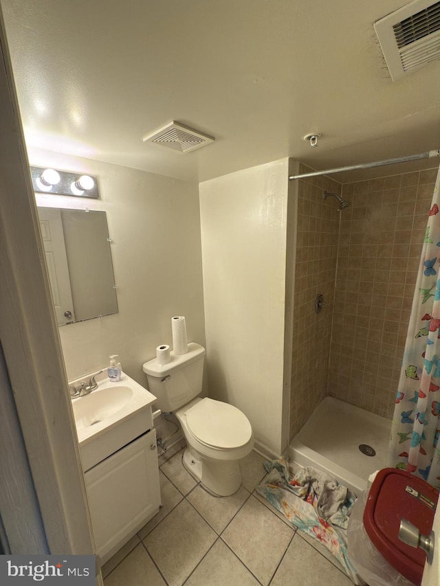 bathroom with toilet, tile patterned flooring, vanity, and walk in shower