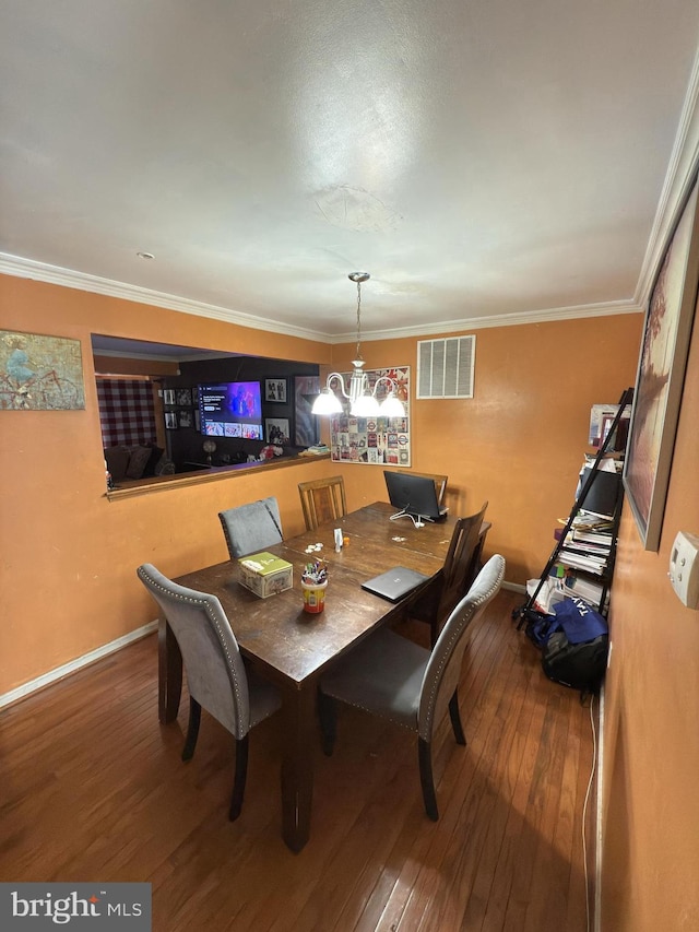 dining space with hardwood / wood-style flooring, an inviting chandelier, and ornamental molding