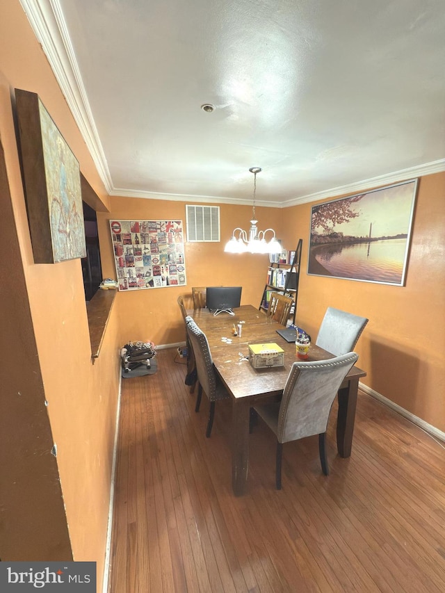 dining space with a chandelier, hardwood / wood-style flooring, and crown molding