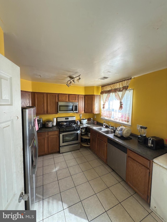 kitchen with sink, light tile patterned floors, and stainless steel appliances