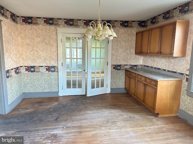 kitchen featuring pendant lighting, a notable chandelier, and light hardwood / wood-style flooring