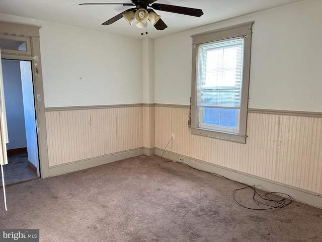 empty room featuring ceiling fan and light colored carpet