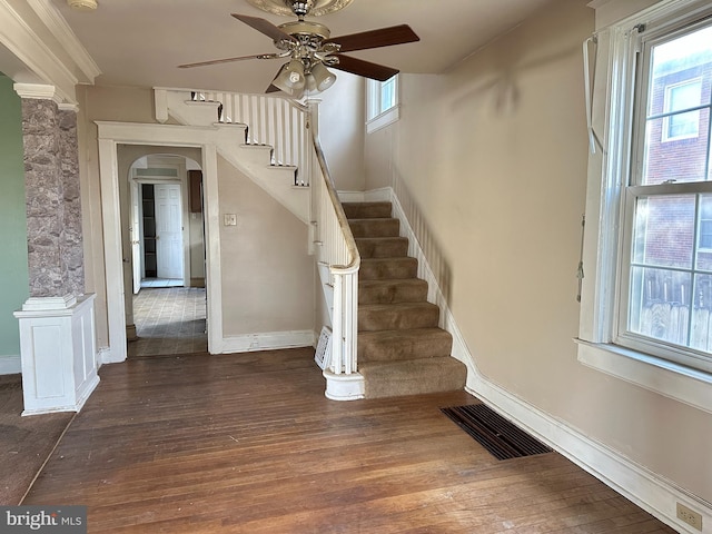 stairs with hardwood / wood-style flooring, ceiling fan, and a healthy amount of sunlight