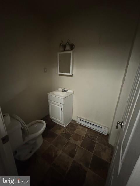 bathroom with vanity, toilet, and baseboard heating