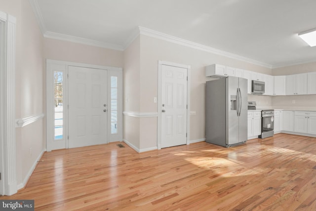 foyer with light hardwood / wood-style floors and ornamental molding