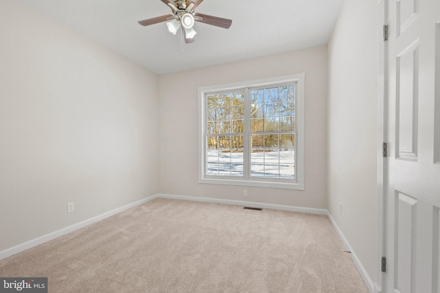 empty room with ceiling fan and light carpet