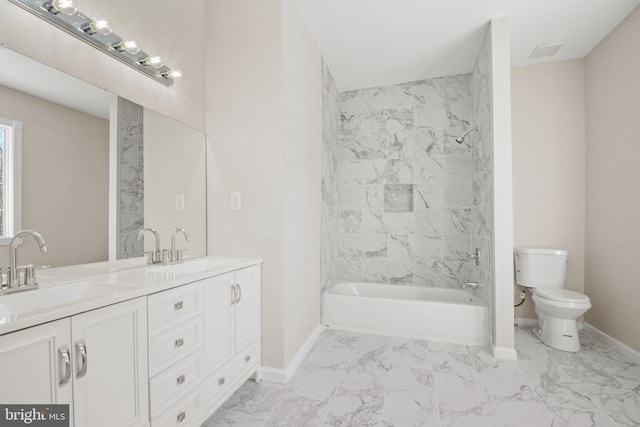 full bathroom with toilet, vanity, and tiled shower / bath