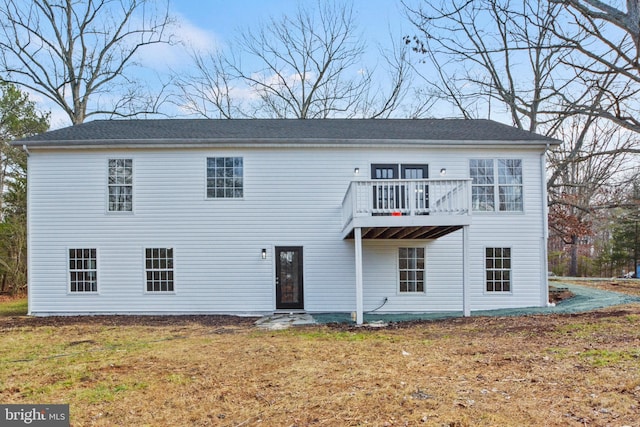 rear view of property with a yard and a balcony