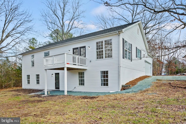 back of property featuring a garage, a patio area, and a lawn