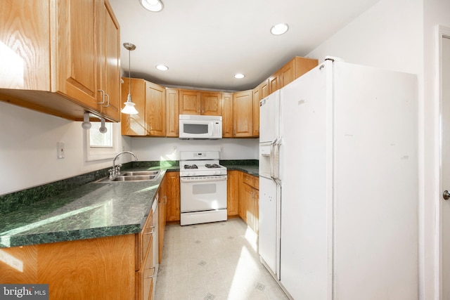 kitchen with white appliances, decorative light fixtures, and sink