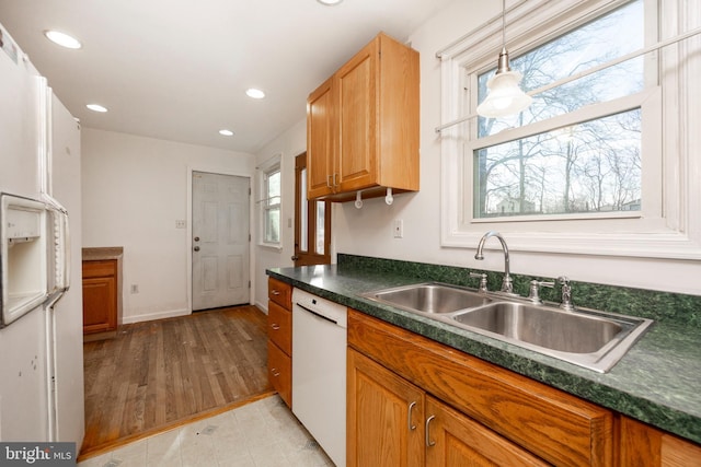 kitchen featuring pendant lighting, white appliances, a wealth of natural light, and sink