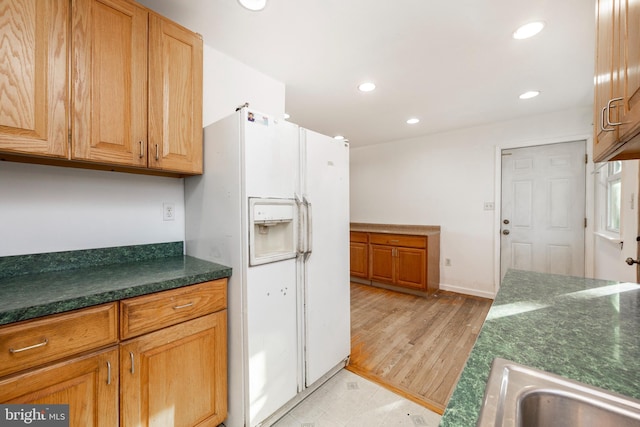 kitchen with white fridge with ice dispenser, light hardwood / wood-style flooring, and sink