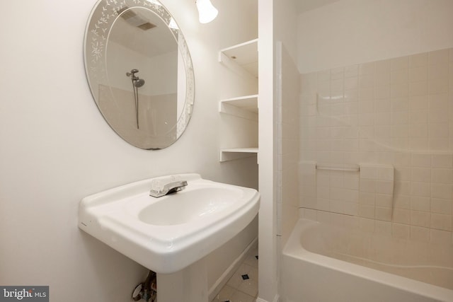 bathroom featuring tile patterned flooring, shower / bathtub combination, and sink