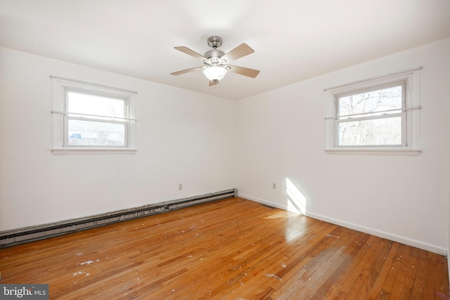 unfurnished room featuring ceiling fan, wood-type flooring, and a baseboard radiator