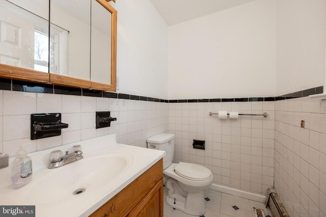 bathroom with tile patterned floors, vanity, toilet, and tile walls