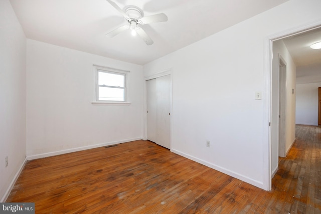 empty room with ceiling fan and dark wood-type flooring