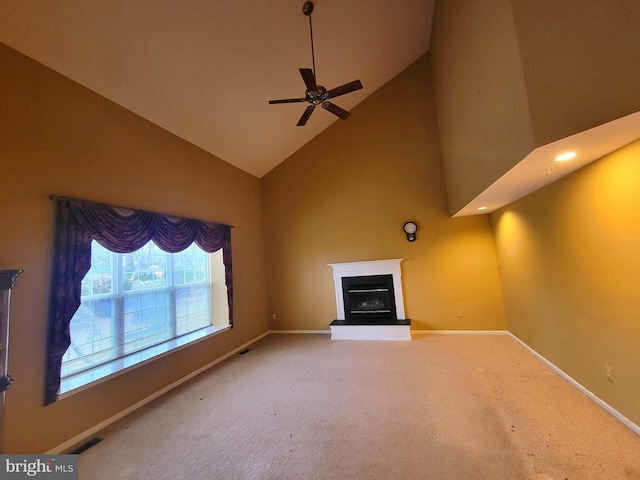 unfurnished living room with high vaulted ceiling, ceiling fan, and carpet flooring