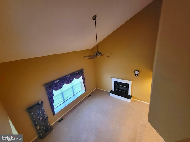 unfurnished living room featuring a fireplace with raised hearth, high vaulted ceiling, light colored carpet, a ceiling fan, and baseboards