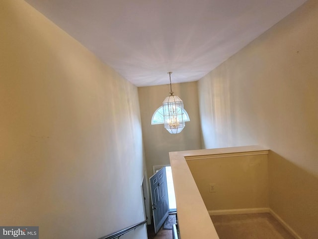 staircase featuring carpet and a notable chandelier