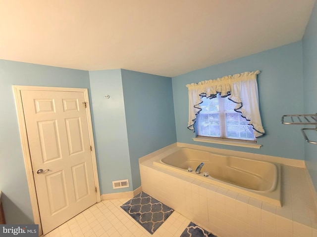 bathroom featuring a garden tub, baseboards, visible vents, and tile patterned floors