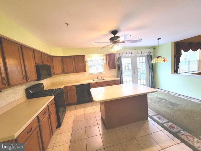 kitchen with sink, light tile patterned floors, a kitchen island, pendant lighting, and black appliances